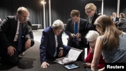 Secretary of State John Kerry (2nd L), Under Secretary for Political Affairs Wendy Sherman (2nd R) and staff watch a tablet in Lausanne, Switzerland as President Barack Obama makes a state address on the status of the Iran nuclear program talks, April 2.