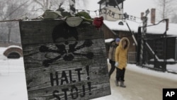 A rose is placed on top of a sign that reads "Stop" with a skull painted, near the gate at the concentration camp during a ceremony marking the 68th anniversary of the liberation of the Auschwitz and to remember the victims of the Holocaust, in Oswiecim, 