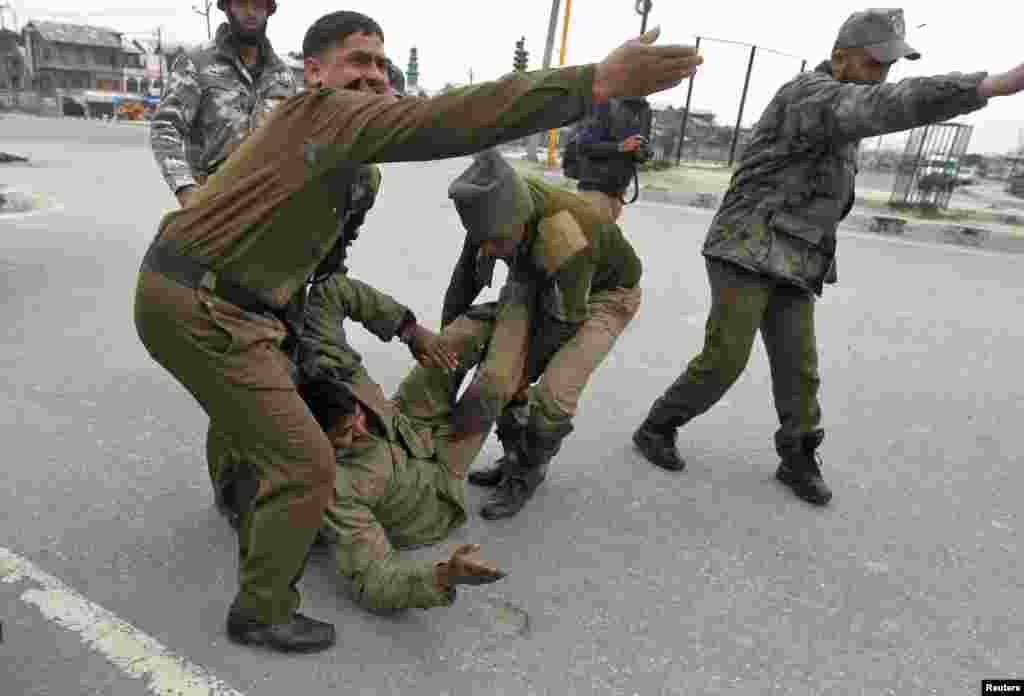 Indian paramilitary soldiers move their wounded colleague during a gun battle in Srinagar, Indian Kashmir, March 13, 2013.