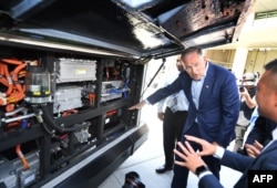 Democratic presidential hopeful Jay Inslee inspects an electric bus during a tour of the Los Angeles Department of Transportation bus depot in Los Angeles, May 3, 2019.