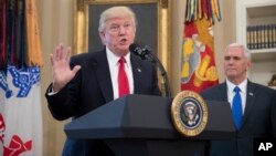 President Donald Trump, accompanied by Vice President Mike Pence, right, speaks during a signing ceremony for executive orders regarding trade in the Oval Office at the White House, March 31, 2017, in Washington. 