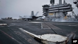 In this Wednesday, April 15, 2015 image released by U.S. Navy Media Content Services, an F/A-18E Super Hornet, assigned to the Knighthawks of Strike Fighter Attack Squadron 136, lands on the flight deck aboard Nimitz-class aircraft carrier USS Theodore Ro