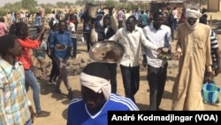 Les étudiants sur les cendres de leur restaurant brûlés par la police entonnant l'hymne national, à N'Djamena, Tchad, le 14 février 2017. (VOA/André Kodmadjingar)