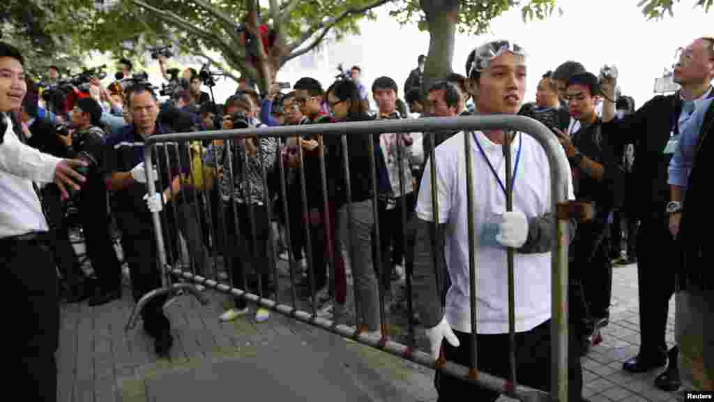 支持民主的抗议示威者（右）和一名工人按照法院清除部分路障的命令拆除栏栅