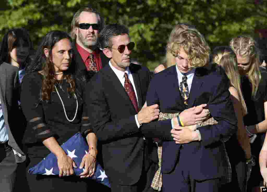 Parents of Riley Howell, Natalie Henry-Howell, center left, stands next to Thomas Howell, comforting their son Teddy, after a memorial service for Riley Howell in Lake Junaluska, North Carolina, May 5, 2019. Family and hundreds of friends and neighbors are remembering Howell, a North Carolina college student credited with saving classmates' lives by rushing a gunman firing inside their lecture hall.