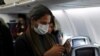 Una mujer con máscara chequea su teléfono después de arribar a Nueva York, en un vuelo desde San Francisco. Aeropuerto Internacional JFK. Marzo 5, 2020. 