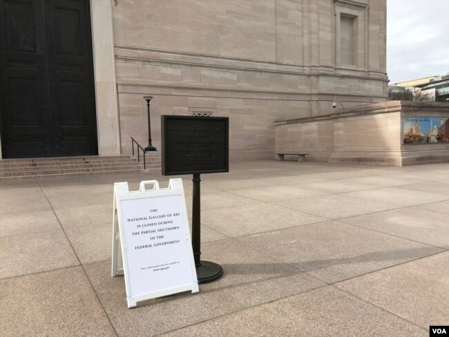 华盛顿史密森尼国家美术馆大门紧闭，门口告示牌向游人解释博物馆因联邦政府关闭而关门。（2019年1月23日）