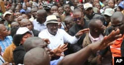 Kenya's opposition leader, Raila Odinga, centre, joins his supporters in the Mathare area where four people were killed overnight, in Nairobi, Nov. 19, 2017.