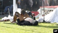 An injured person lies on his back at White City Stadium following a bomb blast last Saturday soon after President Emmerson Mnangagwa addressed members of the public.