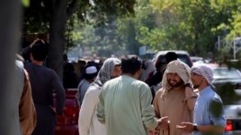 Afghans wait for hours to try to withdraw money, in front of Kabul Bank, in Kabul, Afghanistan, Saturday, Aug. 28, 2021.