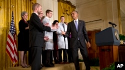 President Barack Obama turns to shake hands with Dr. Kent Brantly, 33, an Ebola survivor, after speaking at a White House event with American health care workers fighting Ebola, Oct. 29, 2014.