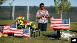Angélica Cervantes lleva flores de su casa a la tumba de su hijo Erick Silva en Las Vegas, el sábado 29 de septiembre de 2018. Silva, un guardia de seguridad en el concierto Festival de la Cosecha Route 91 fue una de las 58 personas asesinadas el 1 de octubre de 2017 en el peor tiroteo masivo en la historia moderna de Estados Unidos.