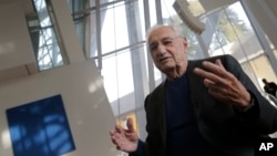Frank Gehry, center, speaks to journalists during the press day at his latest creation, the Louis Vuitton Foundation art museum and cultural center, in Paris, Oct. 17, 2014.
