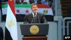 In this handout picture Egyptian President Mohammed Morsi gives a speech to thousands of Islamists and Syrian opposition supporters during the "support for Syria" rally at Cairo stadium, June 15, 2013 in Cairo, Egypt. (Credit: Ho/Egyptian Presidency)