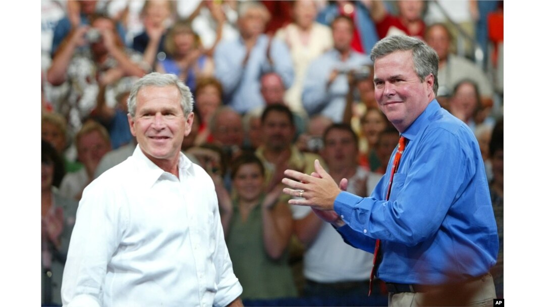 FILE - President George W. Bush, left, is introduced by his brother Florida Governor Jeb Bush, right, at a campaign rally, in Niceville, Florida, August 2004.