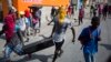 Masked looters carry a flat screen TV amid protests demanding the resignation of Haitian President Jovenel Moise near the presidential palace in Port-au-Prince, Haiti, Feb. 13, 2019. 