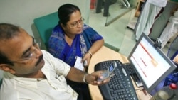 A man sends a text message from his mobile phone at an Internet cafe in the eastern Indian city of Kolkata