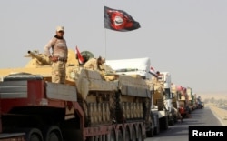 FILE - A convoy of Iraqi security forces advances on the outskirts of Mosul, Oct. 12, 2016. The battle for Mosul is weeks or perhaps days away.