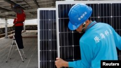 A prisoner places solar panels on the roof of Pingtung prison in Pingtung, Taiwan, Feb. 15, 2017. 