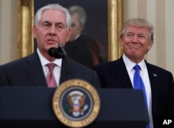 President Donald Trump smiles at Secretary of State Rex Tillerson after he was sworn in in the Oval Office of the White House in Washington, Feb. 1, 2017.