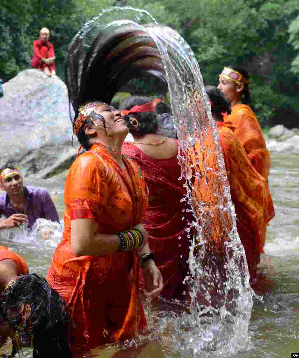 Hindu devotees bathe in the Bagmati River on their way to the Pashupatinath Temple to offer prayers to Lord Shiva, Hindu god of destruction during Shravan festivities in Sundarijal, on the outskirts of Kathmandu, Sri Lanka.