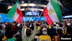 FILE - Supporters of the National Council of Resistance of Iran (NCRI) attend a rally in Villepinte, near Paris, France, June 30, 2018. A foiled attack had targeted the meeting.