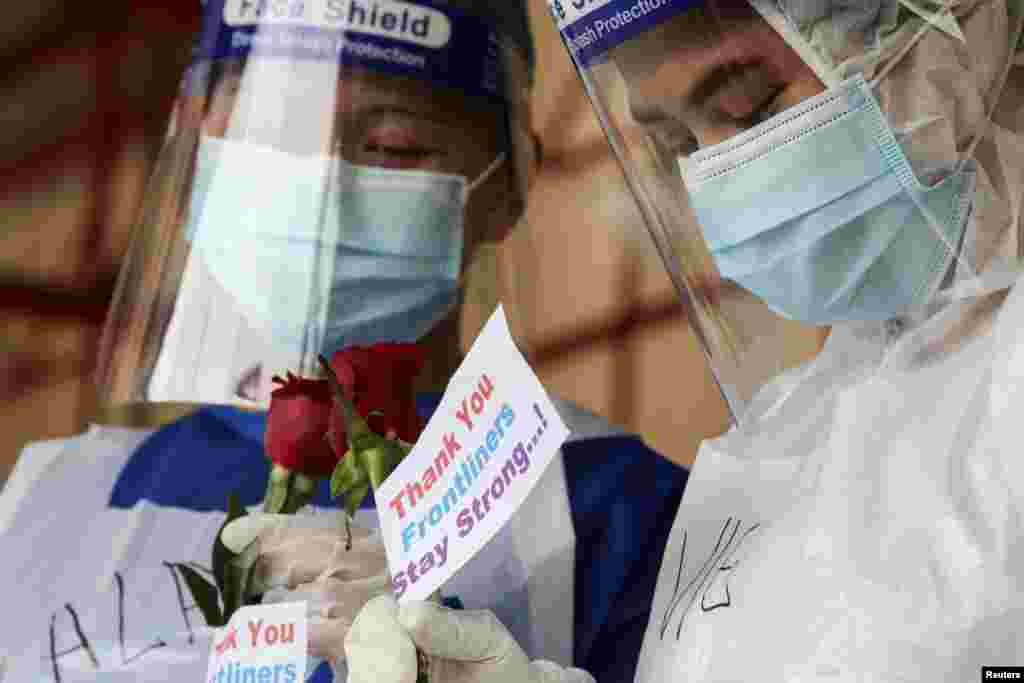 Medical workers hold roses given by members of the public at a coronavirus disease (COVID-19) testing centre in Petaling Jaya, Malaysia.