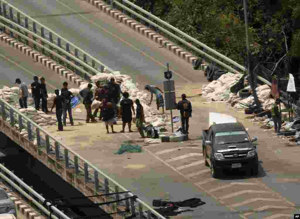 Demonstran anti-pemerintah menyingkirkan barikade yang dipasang pasukan anti huru-hara Thailand di Taman Lumpino, Bangkok, Thailand.