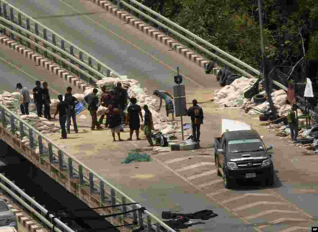 Anti-government protesters dismantle the sandbag barriers, blocking the overfly on the street near their protesting site of Lumpino park in Bangkok, Thailand&#39;s government is lifting a state of emergency in Bangkok and surrounding areas after violence related to the country&rsquo;s political crisis eased.