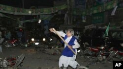 مسلم لیگ (ن) کا ایک کارکن ہاتھ میں ڈنڈا اٹھائے پولیس اہلکاروں کی جانب بڑھ رہا ہے۔
