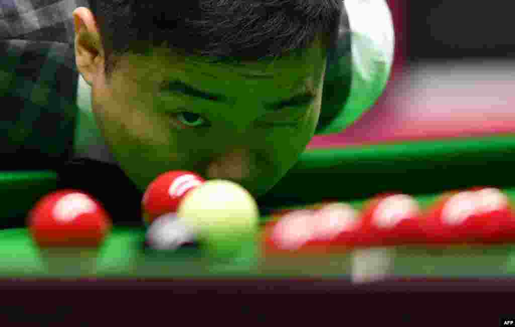 China&#39;s Ding Junhui prepares to play a shot during his quarter-final match against England&#39;s Joe Perry during the Masters Snooker tournament at Alexandra Palace in London.