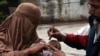 A Pakistani health worker administers polio drops to a child during a polio vaccination campaign in Peshawar on March 3, 2015. Police in northwest Pakistan have arrested more than 450 parents for refusing to vaccinate their children against polio, offici
