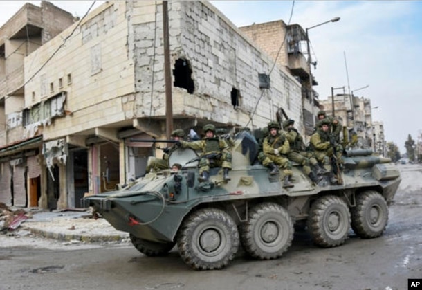 FILE - This undated handout photo released by the Russian Defense Ministry claims to show Russian Military engineers driving in their armored personnel carrier to operate in Aleppo, Syria.