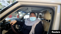 Palestinian woman Naela Abu Jibba, who started a women-only taxi service in the Gaza Strip, sits behind the wheel of her vehicle at Beach refugee camp in Gaza City on November 17, 2020. (REUTERS/Mohammed Salem)