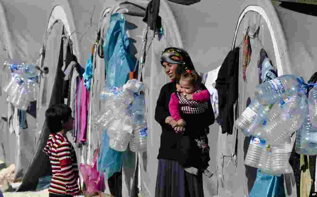 A Syrian Kurdish refugee woman from the Kobani area holds a baby at a camp in Suruc, on the Turkey-Syria border. Kobani, also known as Ayn Arab, and its surrounding areas, has been attacked by extremists of the Islamic State group since mid-September and is being defended by Kurdish fighters.