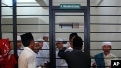 A group of Indonesian Muslims accused of attacking Ahmadiyah followers wait in a cell at a court room in Serang, Indonesia's Banten province July 28, 2011.