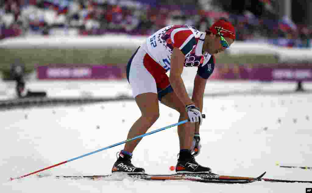 Norway's Chris Andre Jespersen wears a cut suit as he gets to the finish area after completing the men's 15K classical-style cross-country race at the 2014 Winter Olympics, Feb. 14, 2014.