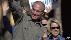 Bob Beauprez and wife Claudia gesture to supporters as they drive by at a honk and wave, Tuesday, Nov. 7, 2006, in Denver.