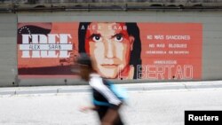 Un hombre pasa frente a un mural en apoyo a la liberación del empresario colombiano Alex Saab, quien se encuentra detenido en Cabo Verde en Caracas. 9 de septiembre de 2021.