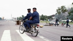 La police congolaise en patrouille, dégage une barricade érigée à une intersection près de l’Echangeur de Limete à Kinshasa, 19 septembre 2016. 