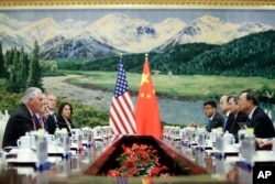 U.S. Secretary of State Rex Tillerson, left, is seen meeting with China's State Councilor Yang Jiechi at the Great Hall of the People, Saturday, Sept. 30, 2017, in Beijing, China.