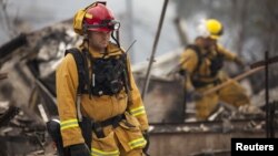 Firefighters search for victims in the rubble of a home burnt by the Valley Fire in Middletown, California, Sept. 14, 2015.