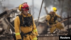 Firefighters search for victims in the rubble of a home burnt by the Valley Fire in Middletown, California, Sept. 14, 2015.