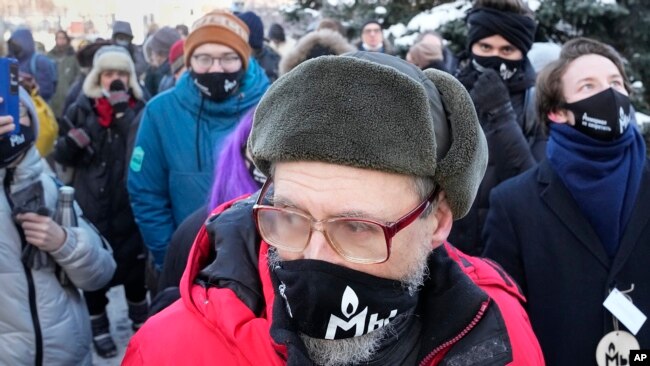 Supporters of the Memorial human rights group wearing face masks with the words "The Memorial cannot be banned!" gather in front of the Moscow Court in Moscow, Russia, Wednesday, Dec. 29, 2021. (AP Photo/Alexander Zemlianichenko) 