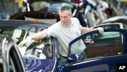 FILE - A worker completes an Opel Corsa car at the German car company Opel Eisenach GmbH, owned by General Motors Corp., in Eisenach, Germany, April 23, 2014.