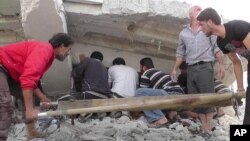 This citizen journalism image shows Syrian citizens searching under rubble to rescue people from a building that was destroyed from a Syrian forces airstrike, at Kfar Nebel town, in Idlib province, northern Syria, October 17, 2012.