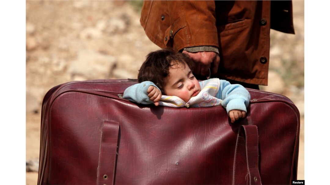 Seorang anak tidur di dalam tas di desa Beit Sawa, Ghouta timur, Suriah 15 Maret 2018.