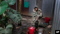 In this April 5, 2016 photo, a Bangladeshi woman collects arsenic-tainted water from a tube-well in Khirdasdi village, outskirts of Dhaka, Bangladesh. 