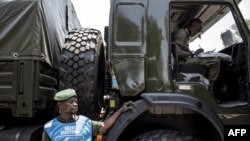 Un chauffeur militaire des Forces armées de la République démocratique du Congo (FARDC) devant des camions militaires alignés le long du boulevard principal le 29 octobre 2018 à Kinshasa.