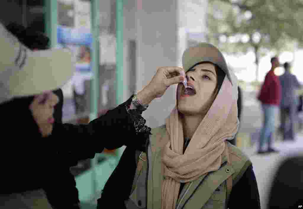 زن جوان در شهر صنعا در یمن، واکسن وبا دریافت می‌کند. جنگ داخلی در این کشور موجب افزایش بیماری ها از جمله وبا شده است. 